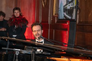 Photo of Chris Reed, painist, at The Kay Mason Foundation Hummingbird Ball a Goodenough House performing his new song 'Hummingbird'