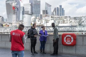 A photo of our fundraising charity expert interviewing a member of the public along the River Thames in London for our charity film.