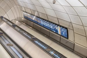 A photo taken on the London Underground of an advert by Educate a Child International on LED panels up the escalator walls for a charity photoshoot and film.